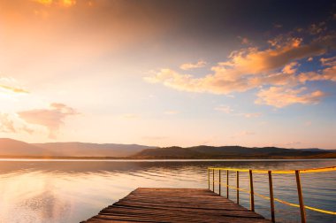 Gün batımında gölün üzerindeki eski ahşap iskelede. Güzel sonbahar manzarası. Güney Ural, Bashkortostan, Rusya