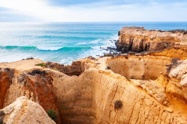 Portekiz, Algarve 'deki Atlantik Okyanusu kıyısındaki kayalar. Güzel yaz deniz manzarası, ünlü seyahat beldesi.