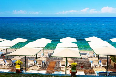 Kemer, Türkiye 'de şemsiyeli çakıl taşı plajı. Güzel yaz deniz manzarası. Seyahat hedefi kavramı