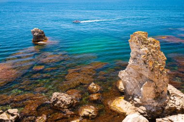Turkuaz suyu ve kayaları olan güzel bir sahil. Kırım yarımadasının batı kıyısında Tarhankut Burnu. Yaz deniz manzarası, ünlü seyahat beldesi.