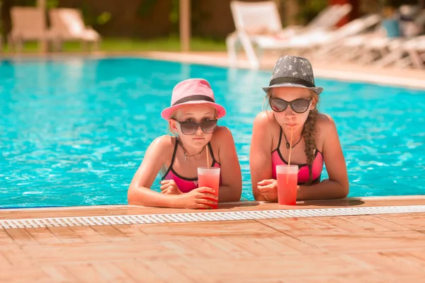 Mutlu kız havuzda içecekler zevk iyi vakit geçiriyor