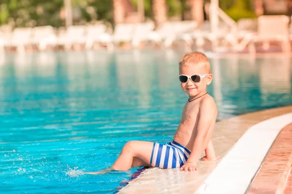 Sevimli Küçük Çocuk Havuzu Kenarında Oturan Güneş Gözlüğü — Stok fotoğraf