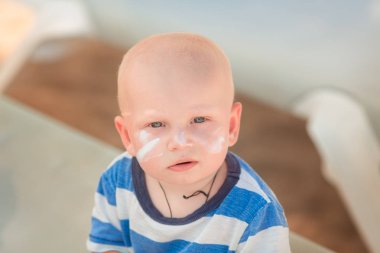 Şirin bebek çocuk kumsalda Güneş Losyonu Şişe tutan güneş kremi ile