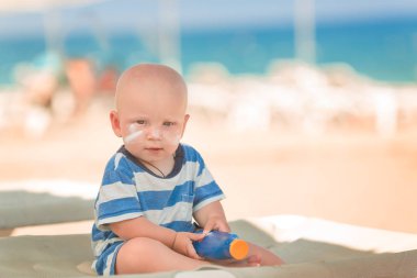 Şirin bebek çocuk kumsalda Güneş Losyonu Şişe tutan güneş kremi ile