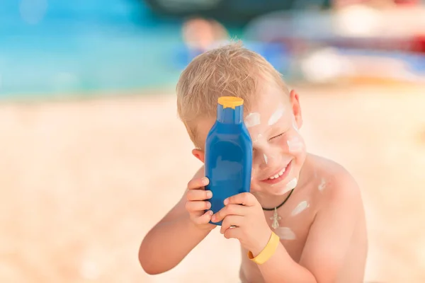 Lindo Niño Pequeño Con Protector Solar Celebración Botella Crema Solar —  Fotos de Stock