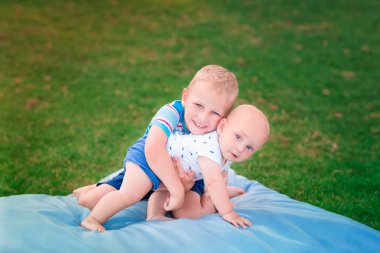 Çimenlerin üzerinde oynarken mutlu iki küçük kardeşler