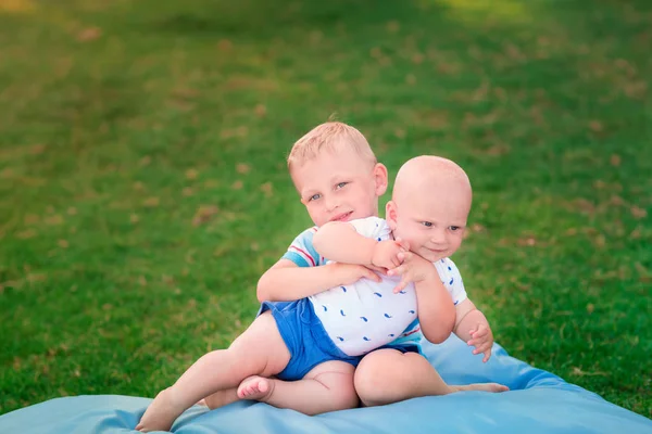 Çimenlerin üzerinde oynarken mutlu iki küçük kardeşler