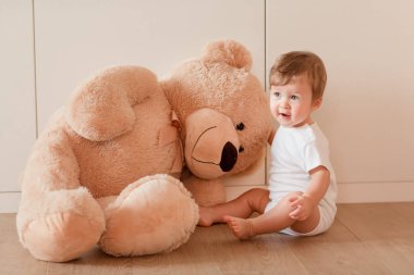 Sevimli küçük oğlu ile oturma odasında büyük bir oyuncak ayı