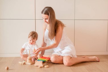 Annesi ile ahşap yığma halkalar ile oynarken şirin küçük oğlu