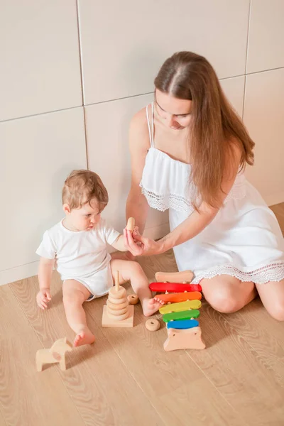 可爱的小男孩与他的母亲玩木制堆叠环 — 图库照片
