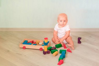 Odasında renkli tahta bloklarla oynama şirin bebek. Erken geliştirme kavramı