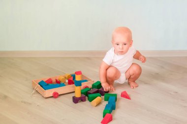 Odasında renkli tahta bloklarla oynama şirin bebek. Erken geliştirme kavramı
