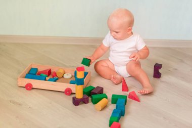 Odasında renkli tahta bloklarla oynama şirin bebek. Erken geliştirme kavramı
