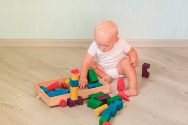 Odasında renkli tahta bloklarla oynama şirin bebek. Erken geliştirme kavramı