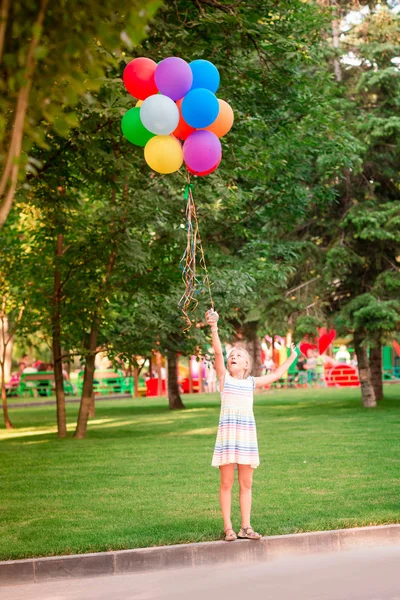 Счастливая Маленькая Девочка Играет Большой Связкой Гелия Заполнены Красочные Воздушные — стоковое фото