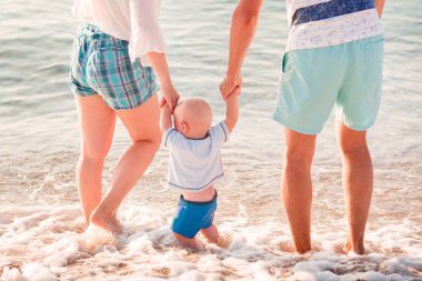 Sahilde deniz kenarında bebekle mutlu aile