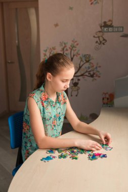 Sevimli küçük kız masada birlikte oturma bulmaca çözme