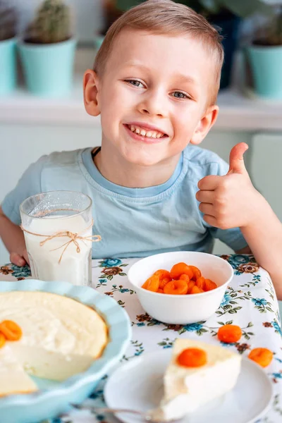 Vakker liten gutt som spiser frokost på kjøkkenet hjemme – stockfoto