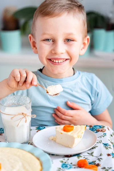 Vakker liten gutt som spiser frokost på kjøkkenet hjemme – stockfoto