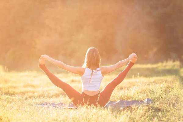Bella giovane donna che pratica yoga nel parco — Foto Stock