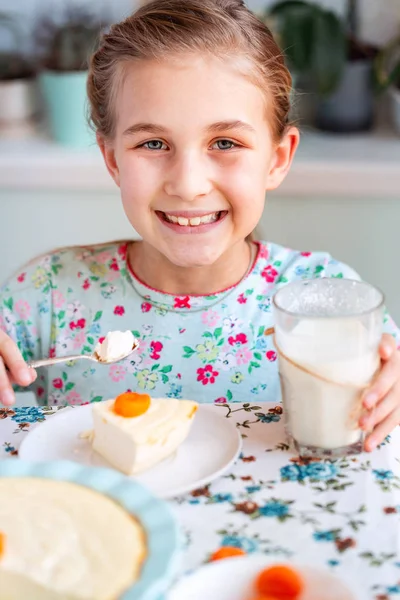 Vakker liten jente som spiser frokost på kjøkkenet hjemme – stockfoto