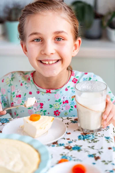 Vakker liten jente som spiser frokost på kjøkkenet hjemme – stockfoto