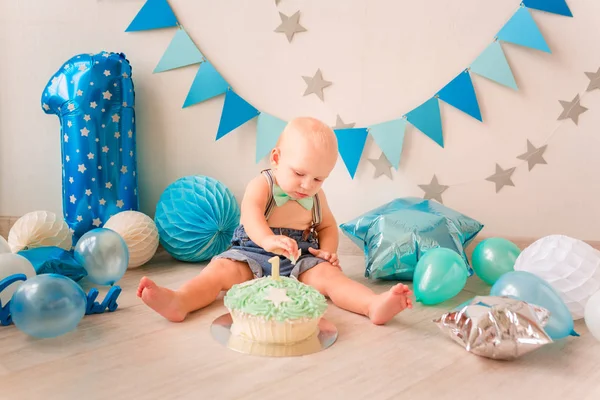 Imádnivaló baba fiú ünnepli első születésnapját. Smash torta. — Stock Fotó