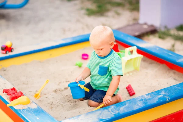 Niedlicher kleiner Junge spielt im Sandkasten — Stockfoto