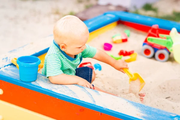 Bonito menino brincando na caixa de areia — Fotografia de Stock