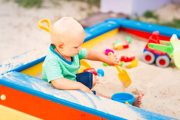 Cute baby boy playing in the sandbox — Stock Photo, Image