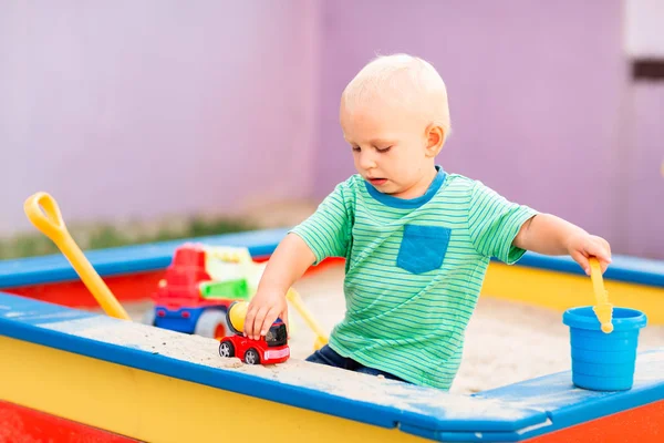 Bonito menino brincando na caixa de areia — Fotografia de Stock