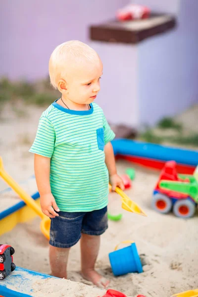 Niedlicher kleiner Junge spielt im Sandkasten — Stockfoto