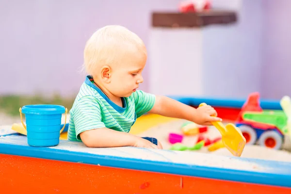 Bonito menino brincando na caixa de areia — Fotografia de Stock