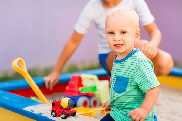 Bonito menino brincando na caixa de areia — Fotografia de Stock