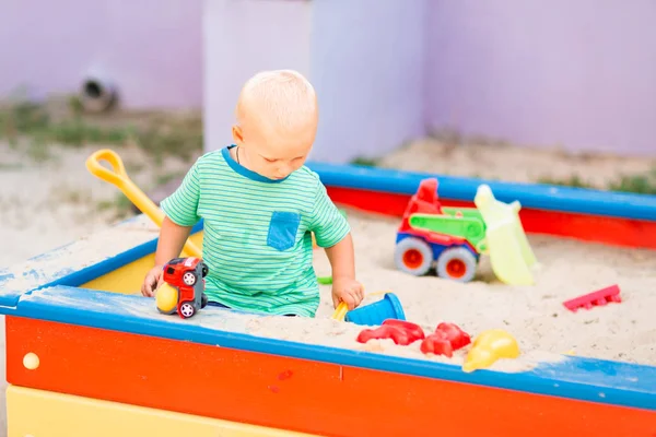 Bonito menino brincando na caixa de areia — Fotografia de Stock