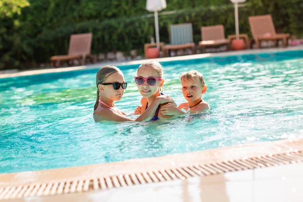 プールで楽しい楽しみを持っている幸せな子供たち — ストック写真