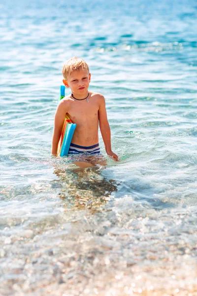 Feliz niño jugando en las olas en la playa —  Fotos de Stock