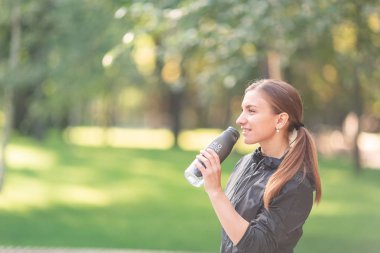 Fitness egzersizleri sırasında mutlu sportif kadın içme suyu