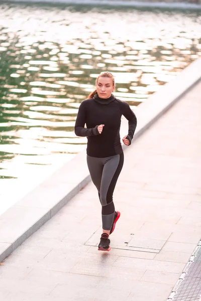 Beautiful young sportive woman jogging in the park