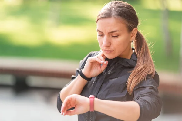 Mooie sportieve meid die haar puls controleert tijdens fitnessoefeningen, joggen — Stockfoto