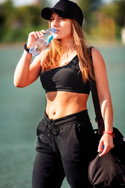 フィットネスエクササイズ中に水を飲む幸せなスポーツ女性 — ストック写真