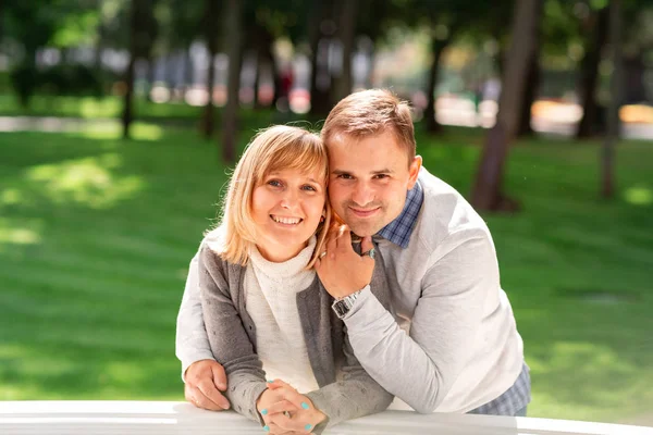 Glückliches junges Paar, das sich im Park umarmt und lacht — Stockfoto