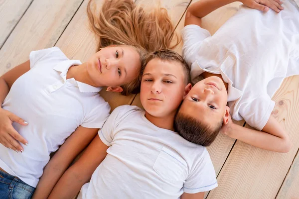 Happy little kids lying on the floor indoors — Stock Photo, Image