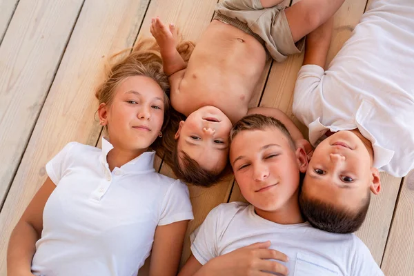 Crianças pequenas felizes deitadas no chão dentro de casa — Fotografia de Stock