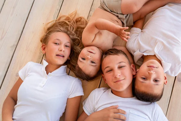 Happy little kids lying on the floor indoors — Stock Photo, Image