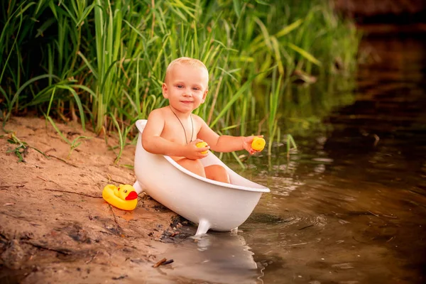 Милий хлопчик грає у ванній на березі річки — стокове фото