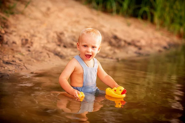 Bonito menino brincando na margem do rio — Fotografia de Stock