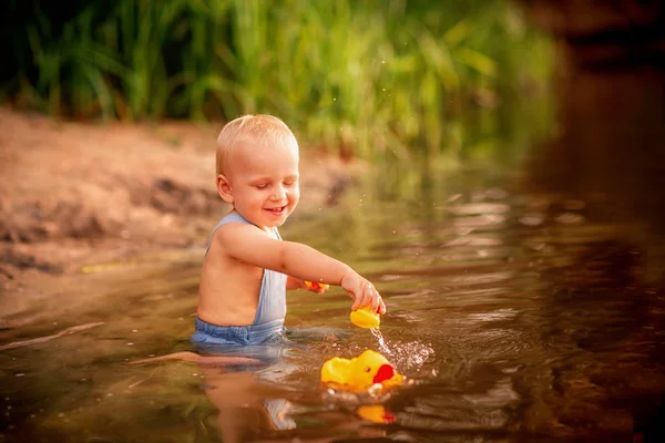 Bonito menino brincando na margem do rio — Fotografia de Stock