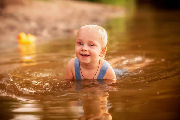 Милий хлопчик грає на березі річки — стокове фото