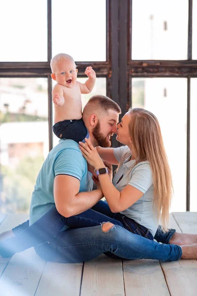 Young happy family with the baby indoors — Stock Photo, Image